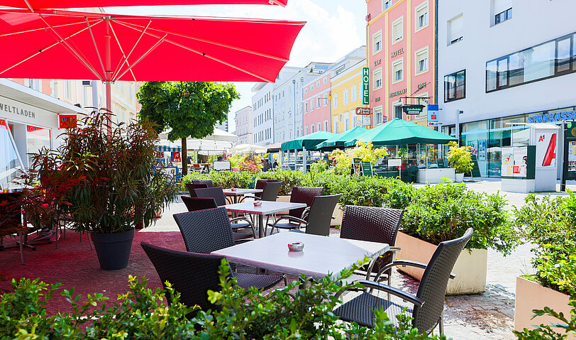 Der gemuetliche Gastgarten von WINWIN Voecklabruck mit zahlreichen gruenen Pflanzen.